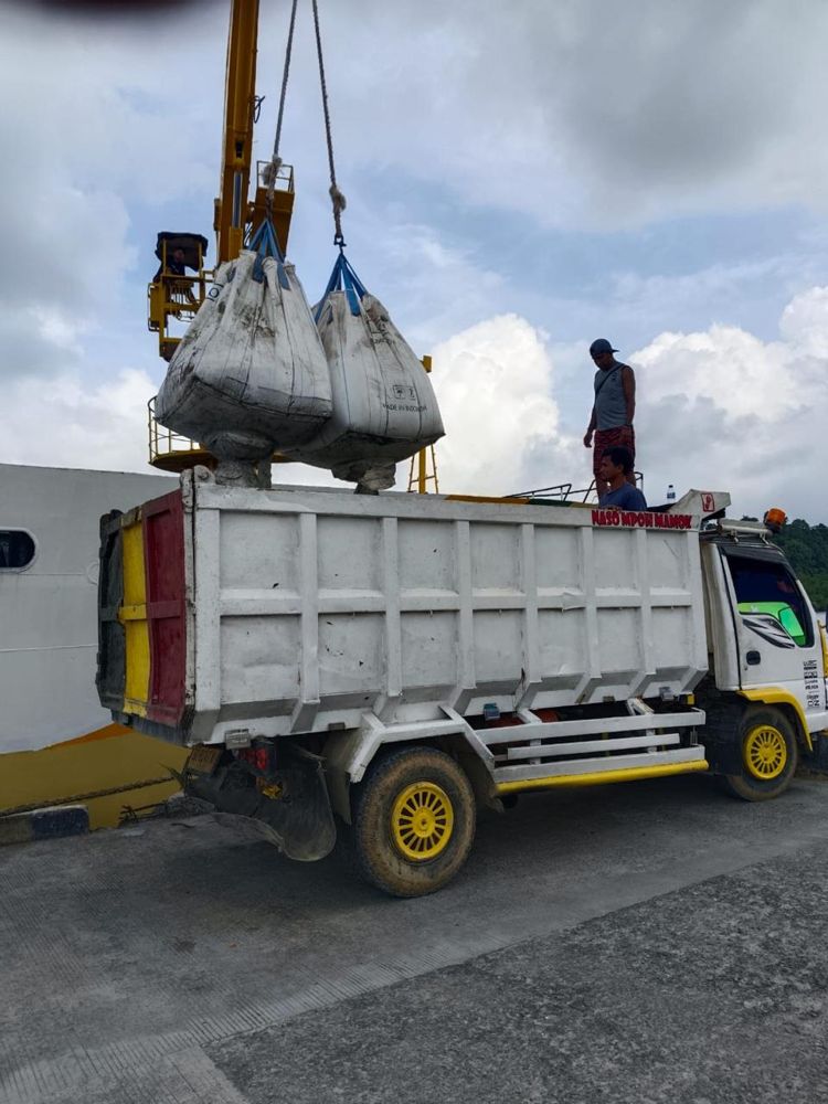 Bulk bags of building material craned from the ship onto a truck at the harbour